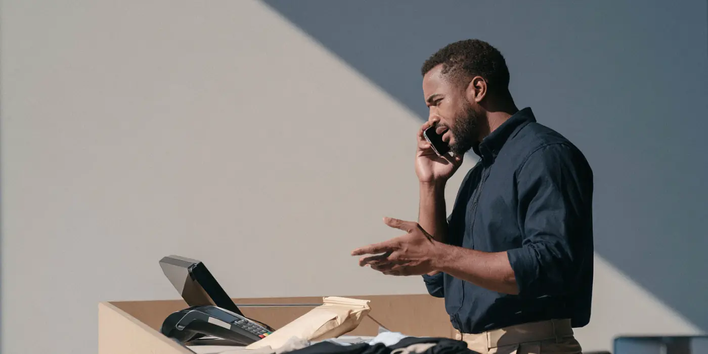 Payments leader discussing a POS issue beside a retail checkout terminal