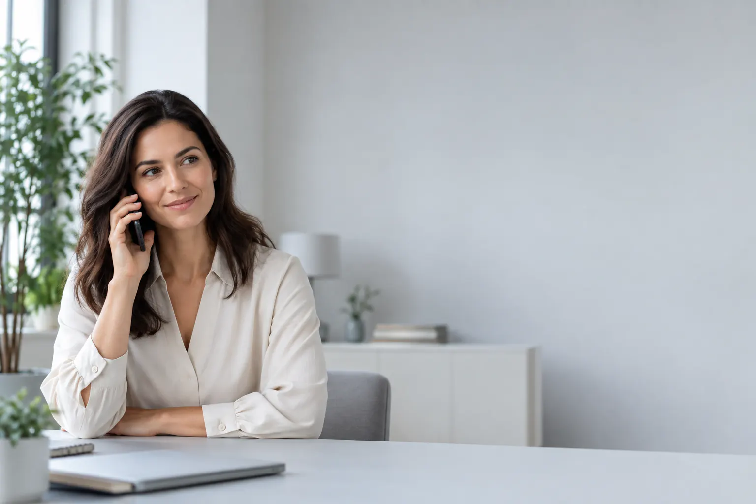 Customer speaking with her bank by phone in a bright home office